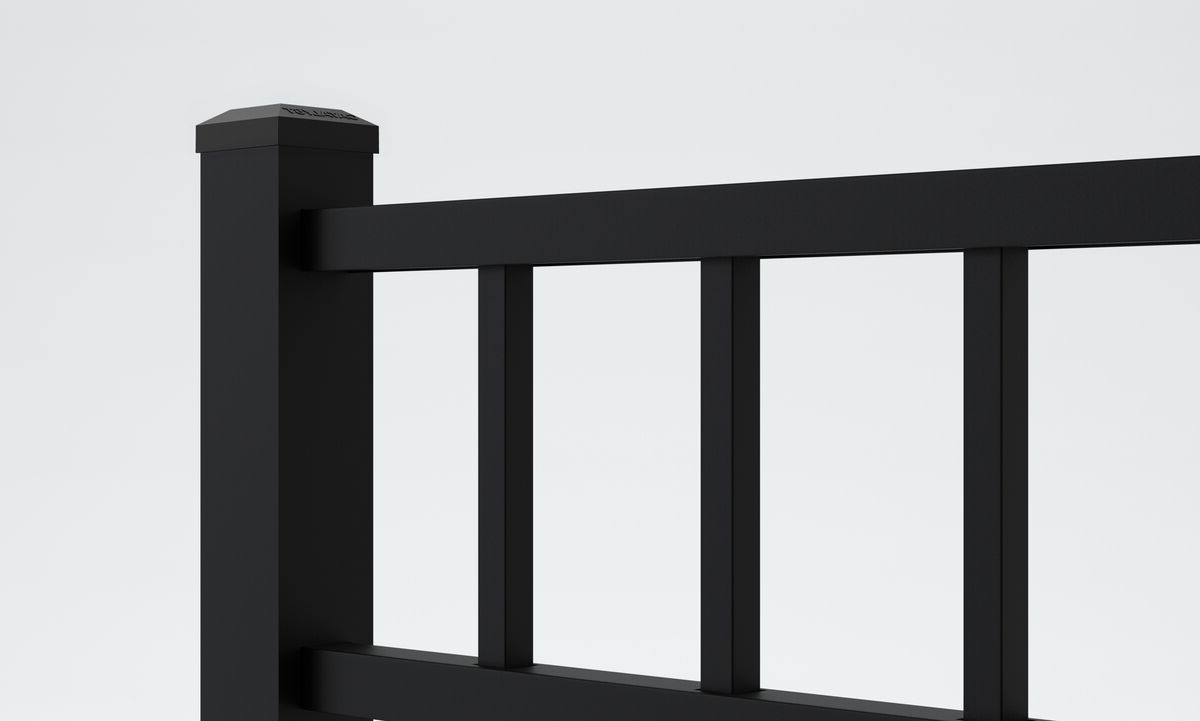 A close-up of a modern black metal fence with vertical bars and a square post against a plain white background.