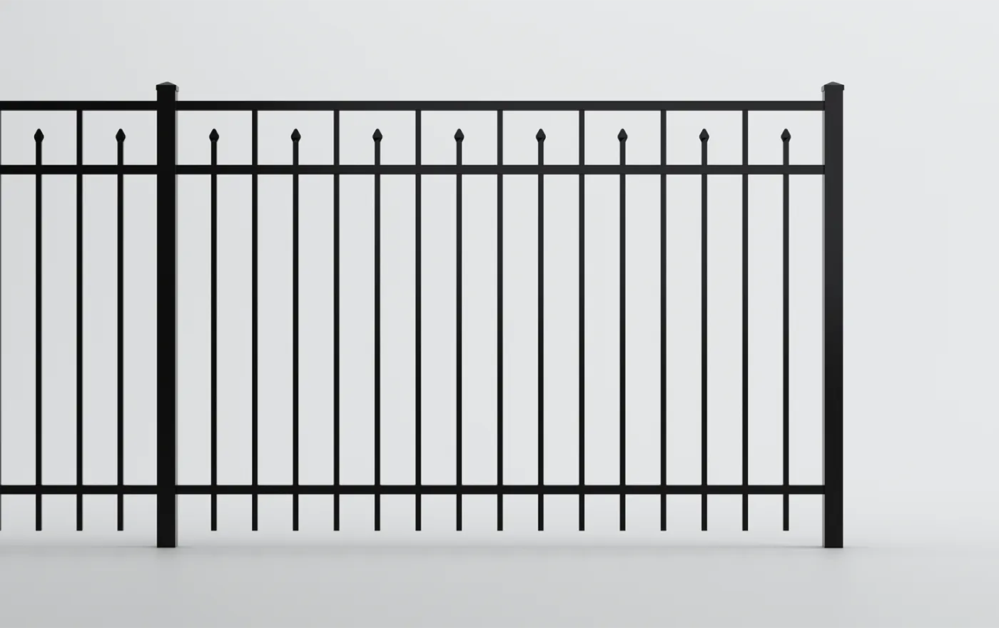 A black metal fence with vertical bars, topped with small pointed details, stands against a plain white background. The design is simple and symmetrical, emphasizing clean, straight lines.