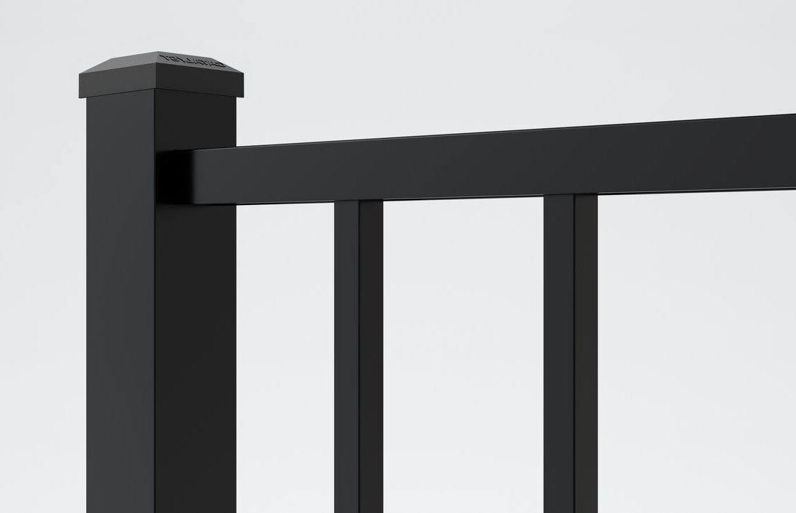 Close-up of a modern black metal railing with vertical bars and a square post, set against a plain light gray background. The design is sleek and minimalistic.
