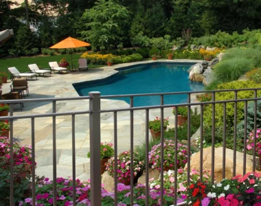 Lexington screwed flat top picket fence in black around back yard with pool
