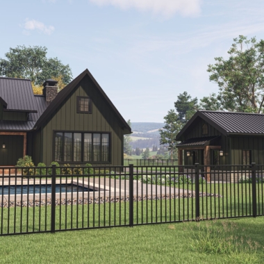 Modern farmhouse with dark siding, black metal roof, and chimney, situated near a pool and patio. A black metal fence runs along the foreground. Trees and distant hills are visible under a partly cloudy sky.