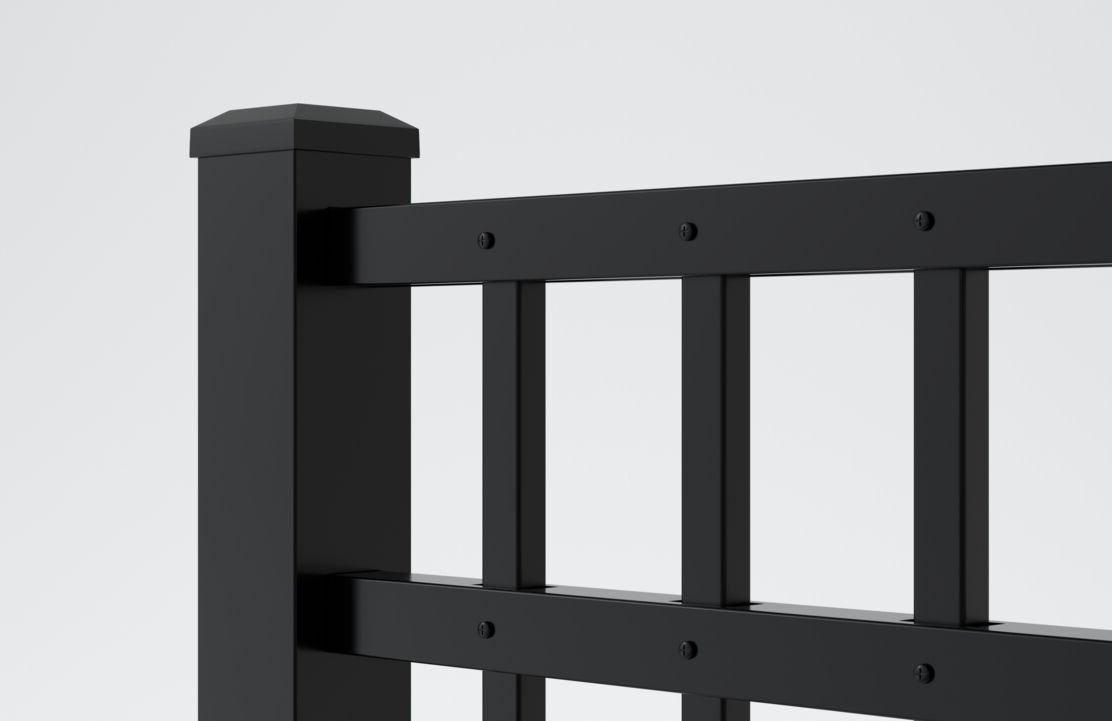 Close-up of a modern black metal fence with vertical and horizontal bars, square post, and capped top, set against a plain light gray background.