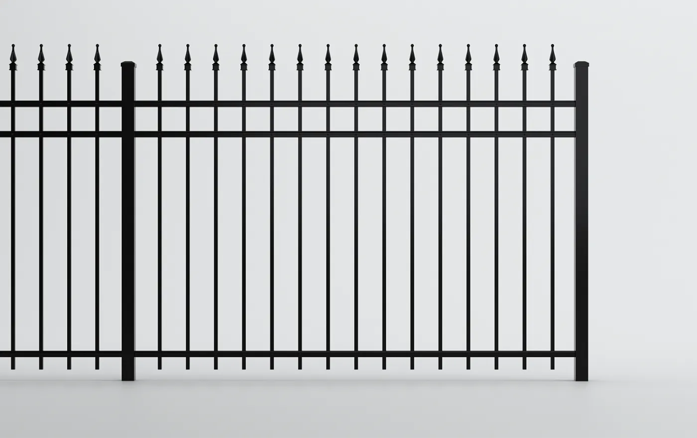 A black metal fence with vertical bars and pointed tips at the top. The fence is against a plain white background, showcasing a simple and elegant design.
