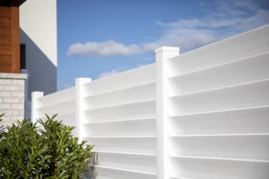 Seaside louvered semi private fence in white around side yard close up