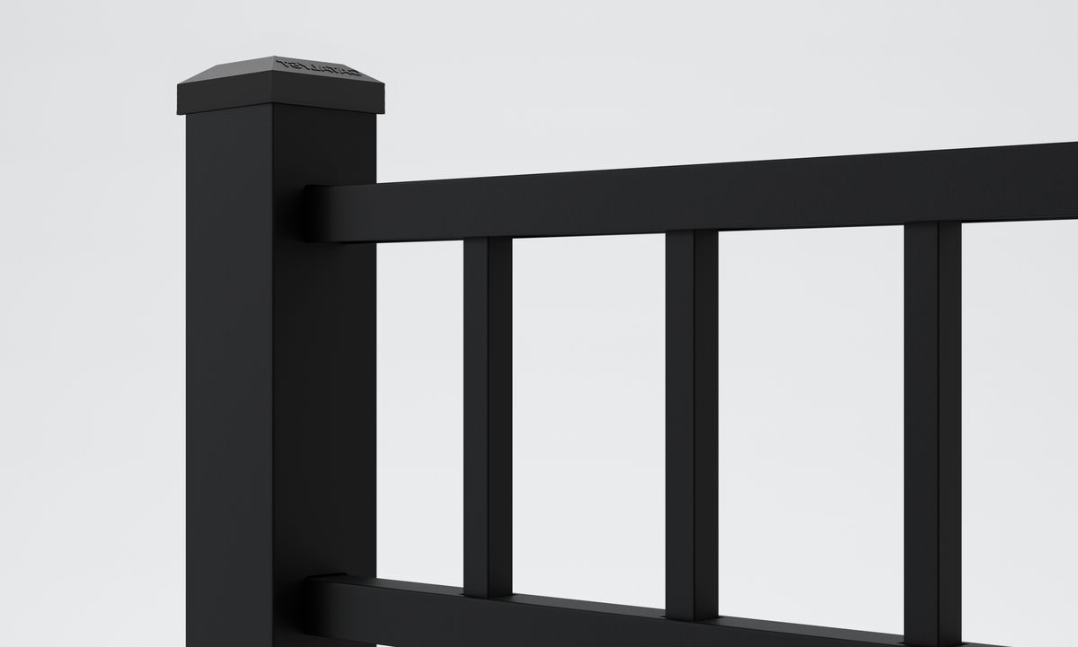 Close-up view of a modern black metal fence with vertical railings and a square post against a plain light background.