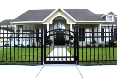 black aluminum fence with gate surrounding front yard