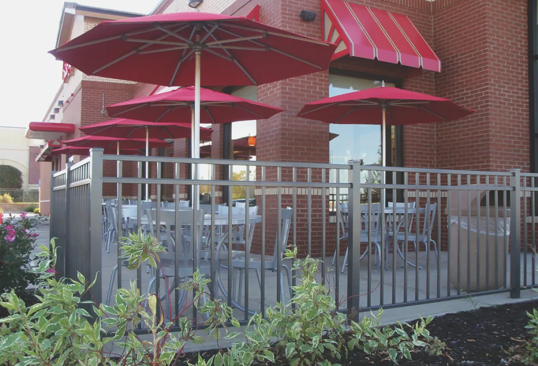 restaurant outdoor seating area surrounded by metal picket fence
