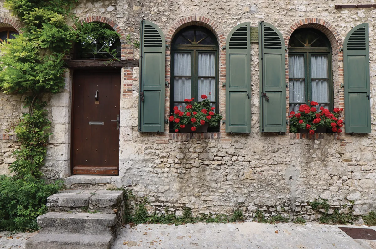 old stone home with green shutters